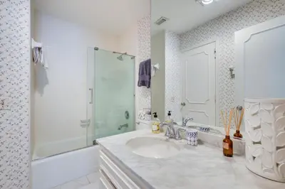 a white bathroom with a sink and a shower at Waterfront Fort Lauderdale House with Heated Pool! in Fort Lauderdale