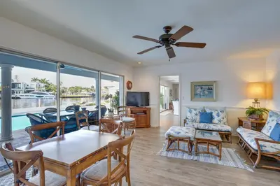 a living room with a ceiling fan and a table and chairs at Waterfront Fort Lauderdale House with Heated Pool! in Fort Lauderdale