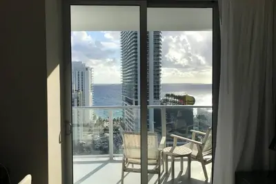a room with a balcony with a view of the ocean at Hollywood Beach luxury condo-HBH in Hollywood