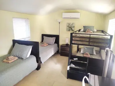 a bedroom with two beds and a bunk bed at Family, Couples Retreat near Airport, Cruise Port & Beaches in Fort Lauderdale