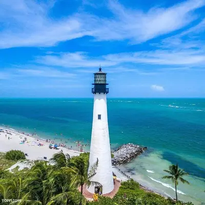 a lighthouse on a beach with people on the beach at Gorgeous Beachy Chic Condo in Key Biscayne in Miami