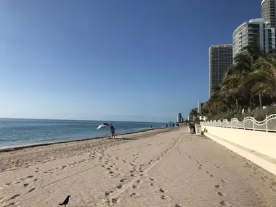 a person standing on a beach with an umbrella at Miami HOLLYWOOD in Hollywood