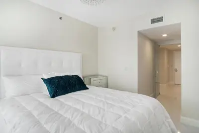 a white bed with a blue pillow on it at NEW!!! W Brickell Miami- ICON DELUXE LOUNGE with 2 masters in Miami