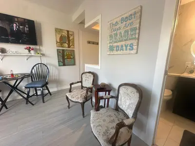 a waiting room with chairs and a table and a sign at Dream Studio on the Beach in Miami Beach
