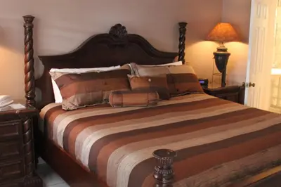 a bedroom with a large bed with a wooden headboard at Coral Reef Guesthouse in Fort Lauderdale