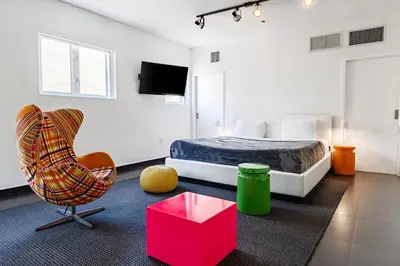a bedroom with a bed and a chair at Blanc Kara- Adults Only in Miami Beach