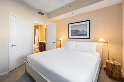 a bedroom with a large white bed in a room at Dharma Home Suites South Miami at Red Road Commons in Miami