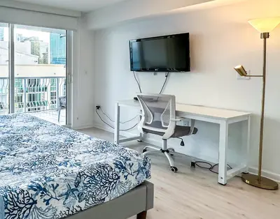 a bedroom with a bed and a desk and a television at Star Stay Miami Orange Brickell in Miami