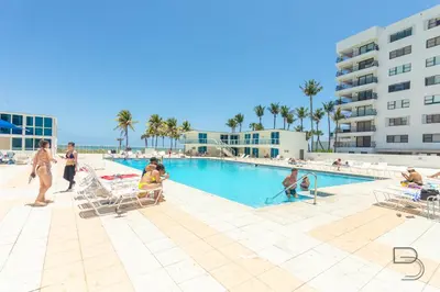 a group of people in a swimming pool at a resort at Girasole Apartments in Miami Beach
