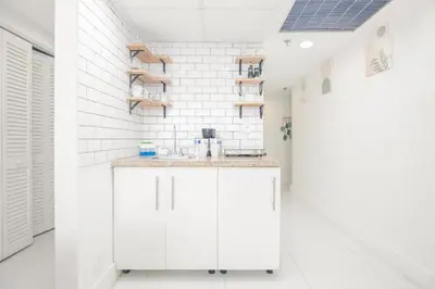 a bathroom with white walls and a sink and shelves at Girasole Apartments in Miami Beach