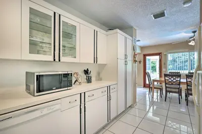 a kitchen with white cabinets and a dining room at Home with Pool in Upscale Pinecrest Village in Miami