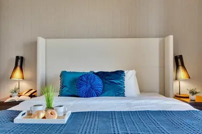 a bed with a blue pillow and a tray of food on it at Luxury Amenities, Infinity Pool, Gym, Hot Tub in Hollywood