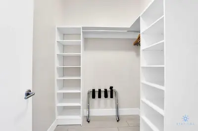 a white walk in closet with white shelves at Luxury Amenities, Infinity Pool, Gym, Hot Tub in Hollywood