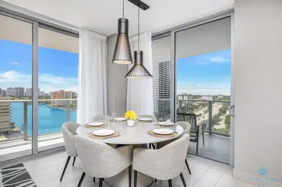 a dining room with a table and chairs and large windows at Corner Balcony - Enjoy 360 Views- Near Beach- Pool in Hollywood