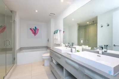 a bathroom with two sinks and a tub and a toilet at Corner Balcony - Enjoy 360 Views- Near Beach- Pool in Hollywood