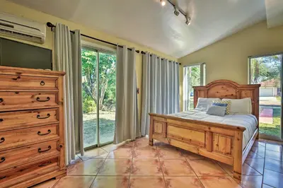 a bedroom with a bed and a dresser and windows at Quaint Central Miami Bungalow 10 Mi to Mid-Beach! in Miami