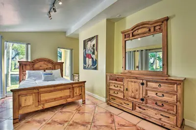 a bedroom with a wooden dresser and a large mirror at Quaint Central Miami Bungalow 10 Mi to Mid-Beach! in Miami