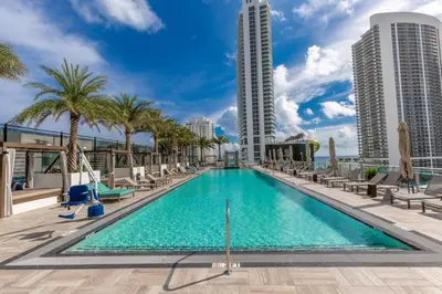 a swimming pool on the roof of a building with palm trees and buildings at Hyde Beach House Luxury Condo-Resort 2808 condo in Hollywood Beach