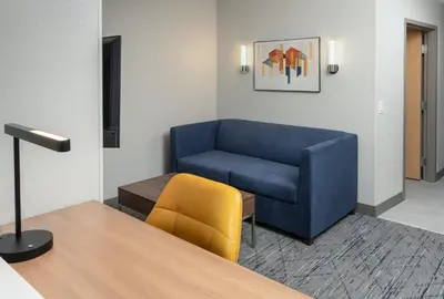 a living room with a blue couch and a yellow chair at Holiday Inn Express Miami Airport-Blue Lagoon Area by IHG in Miami