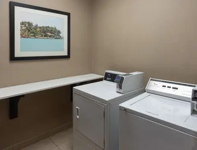 a laundry room with a washing machine and a counter at Holiday Inn Express Miami Airport-Blue Lagoon Area by IHG in Miami