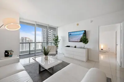 a living room with white furniture and large windows at ICON BRICKELL-29th FLOOR OCEAN VIEWS-FREE SPA in Miami