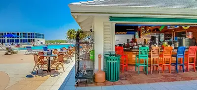 a restaurant with tables and chairs and a pool at Castle 1733 Ocean view studio with direct beach access, pool, tennis & free parking in Miami Beach
