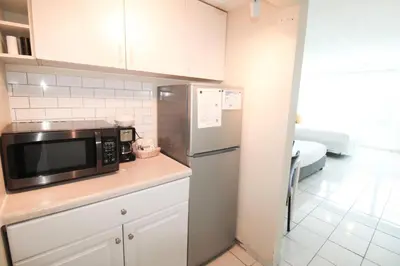 a kitchen with a microwave and a refrigerator at Castle 1733 Ocean view studio with direct beach access, pool, tennis & free parking in Miami Beach