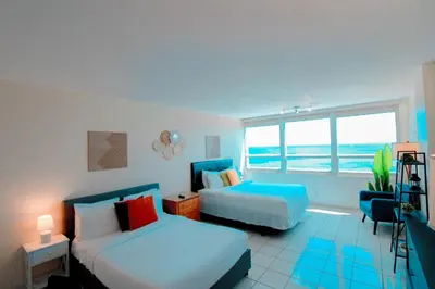 a bedroom with two beds and a view of the ocean at Castle 1733 Ocean view studio with direct beach access, pool, tennis & free parking in Miami Beach