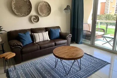 a living room with a brown couch and a table at Beautiful Apartment Steps Away from the Beach in Miami Beach