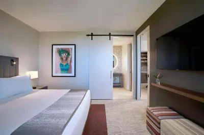 a hotel room with a bed and a flat screen tv at THesis Hotel Miami Coral Gables, Curio Collection by Hilton in Miami