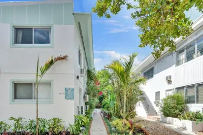 a white building with plants in front of it at Lincoln Villa Suites in Miami Beach