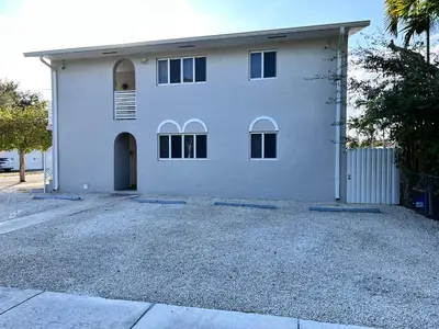 a white house with a driveway in front of it at Stylish Studio Apartment By Miami International Airport in Miami