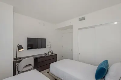 a bedroom with a bed and a desk and a tv at Luxury with stunning view, Balcony, Amazing Pools in Hollywood