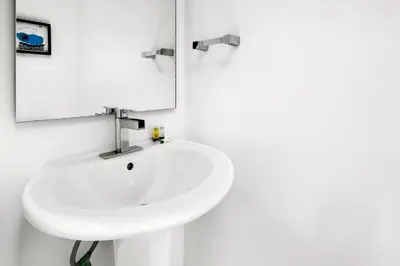 a bathroom with a white sink and a mirror at South Beach Suites in Ocean Drive in Miami Beach