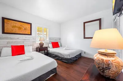 a hotel room with two beds and a lamp at South Beach Suites in Ocean Drive in Miami Beach