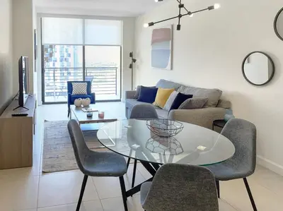 a living room with a glass table and chairs at Provident Grand Luxury Short-Term Residences in Miami