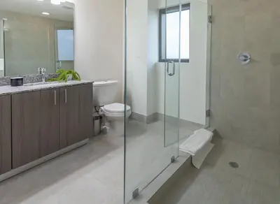 a bathroom with a glass shower and a toilet at Provident Grand Luxury Short-Term Residences in Miami