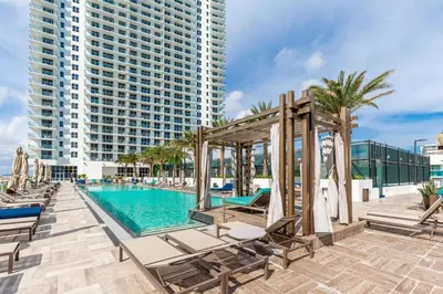 a pool with chaise lounge chairs and a large building at Penthouse 2 Terraces Ocean Views Beach Access in Hollywood