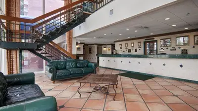 a living room with couches and a staircase in a building at Miami Gardens Inn & Suites in Miami