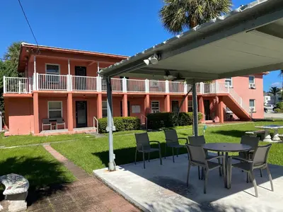 a patio with chairs and a table in front of a building at Rolo Beach Hotel in Fort Lauderdale