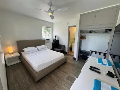a bedroom with a bed and a desk with a television at Rolo Beach Hotel in Fort Lauderdale