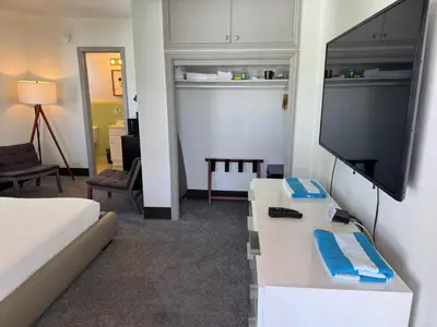 a hotel room with a bed and a flat screen tv at Rolo Beach Hotel in Fort Lauderdale