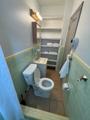 a small bathroom with a toilet and a sink at Rolo Beach Hotel in Fort Lauderdale
