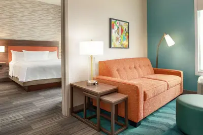 a hotel room with a couch and a bed at Home2 Suites By Hilton Miami Doral West Airport, Fl in Miami