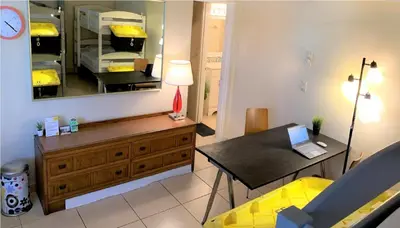 a living room with a table and a mirror at Bposhtels Hollywood Florida in Hollywood