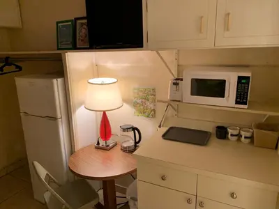 a small kitchen with a table with a lamp and a microwave at Bposhtels Hollywood Florida in Hollywood