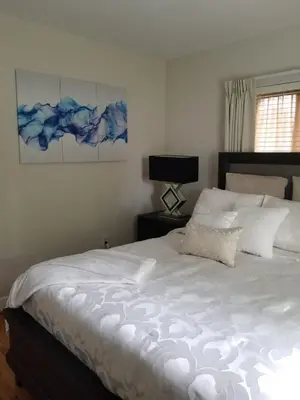 a bedroom with a large bed with white sheets at FAMILY Guayabita's House in Miami