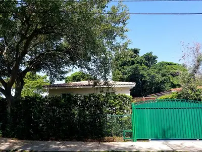 a house with a green fence and a green gate at FAMILY Guayabita's House in Miami