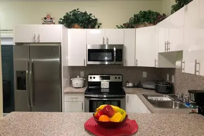 a kitchen with a bowl of fruit on a counter at Your House in Miami in Miami