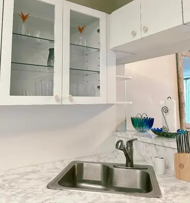 a kitchen with a sink and white cabinets at Pavilion Beach Front Apartment with Balcony in Miami Beach